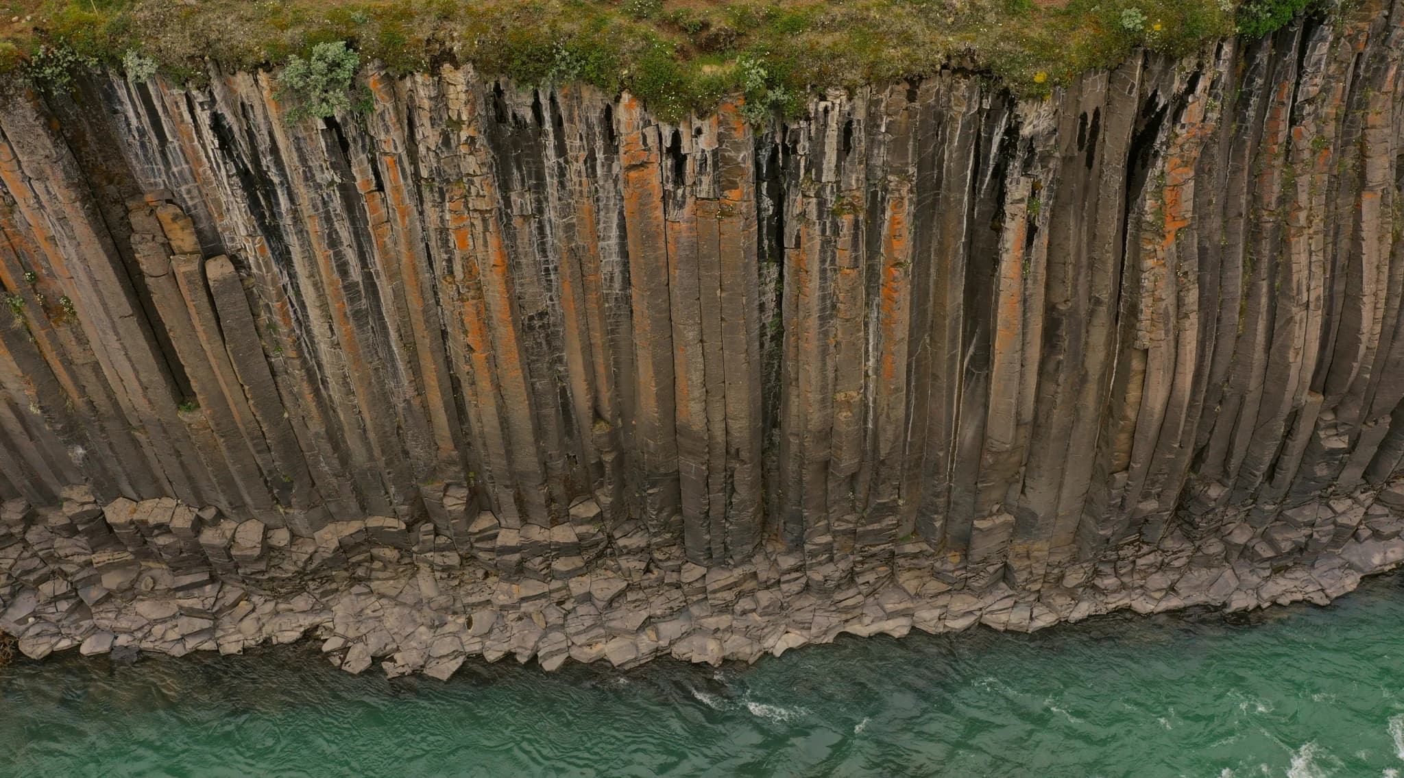 Basalt columns rising above the ocean along a rugged coastline