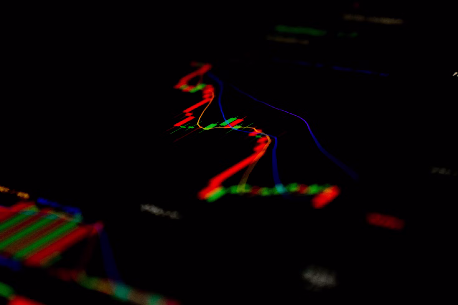 A falling candlestick stock chart glowing red and green against a dark screen